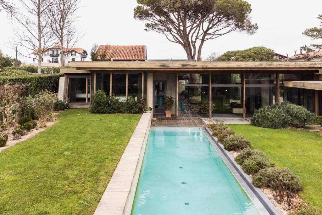- une vue sur l'extérieur d'une maison avec une piscine dans l'établissement EGUZKIA KEYWEEK Villa with pool Biarritz, à Biarritz