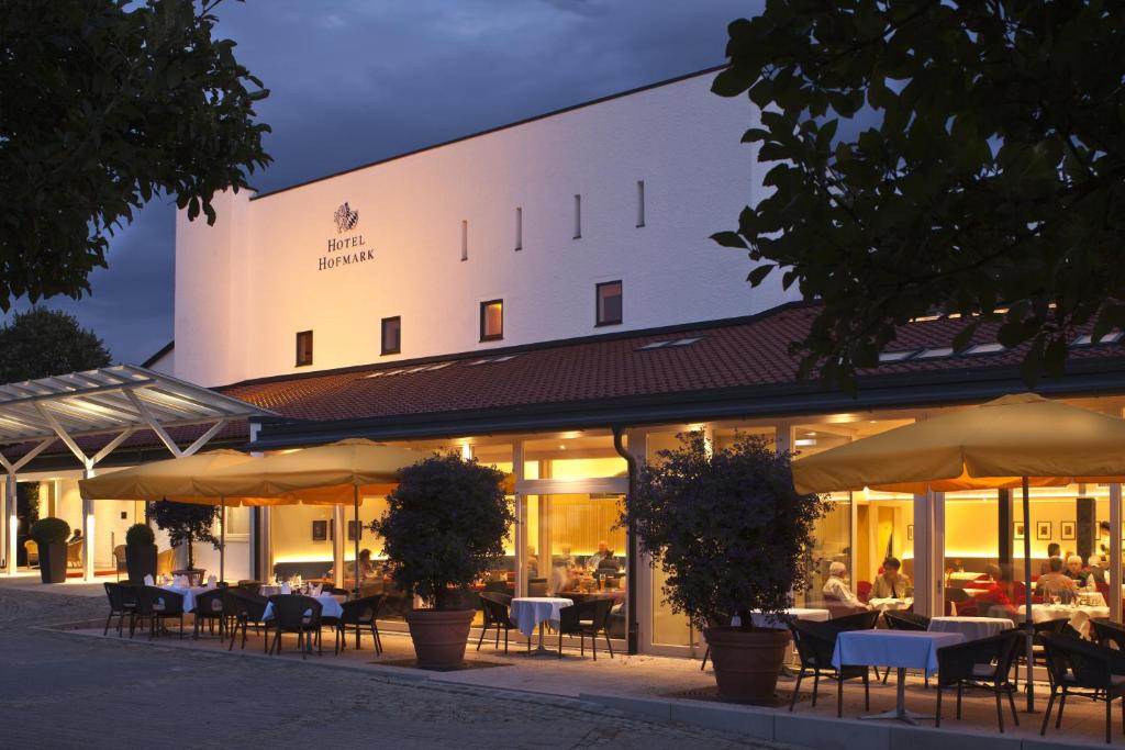a restaurant with tables and umbrellas in front of a building at Hotel Hofmark in Bad Birnbach