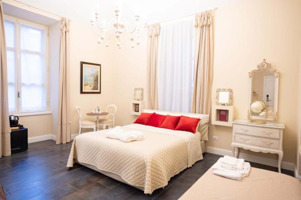 a bedroom with a bed with red pillows and a table at DOMUS DEORUM in Naples