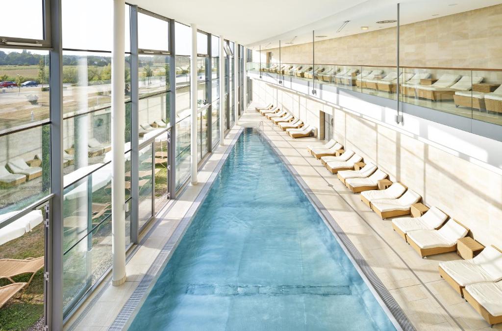 塔亚河畔拉镇Therme Laa Hotel Silent Spa Villas的一个带躺椅的室内游泳池和游泳池