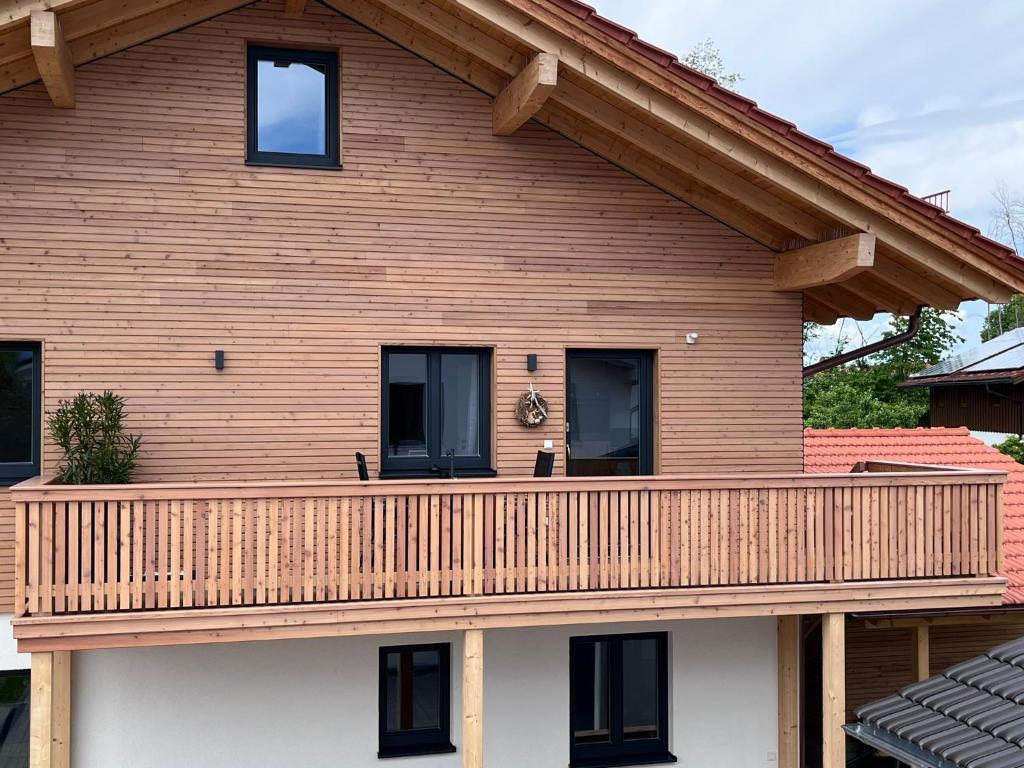 a house with a wooden deck on it at Ferienwohnung Osterbach in Bad Feilnbach