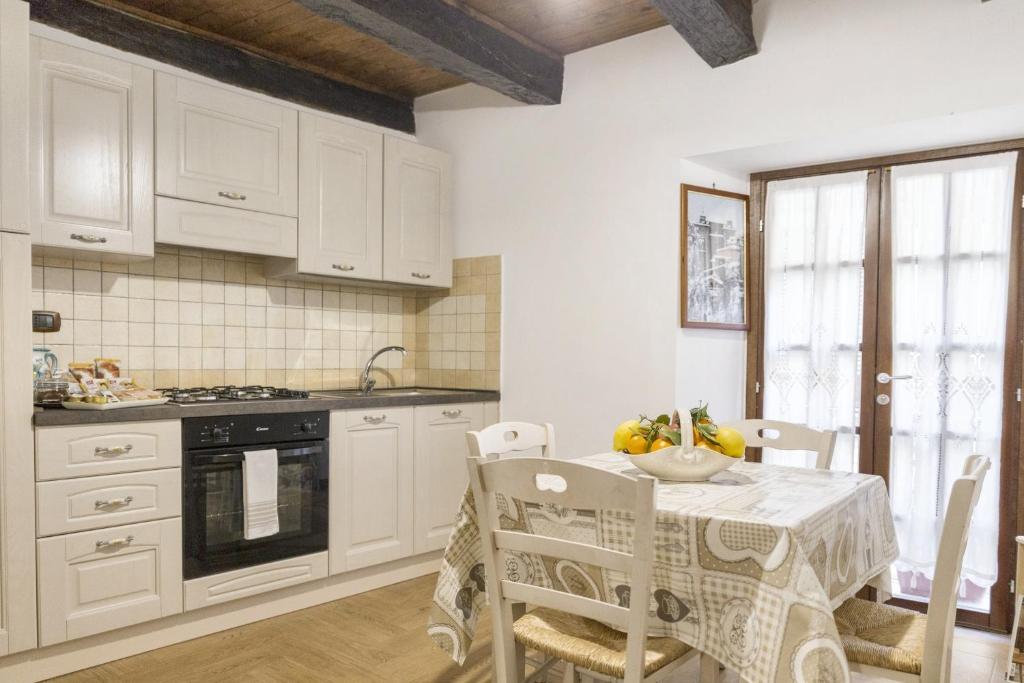 cocina con armarios blancos, mesa y sillas en One bedroom apartement with wifi at Arce, en Arce