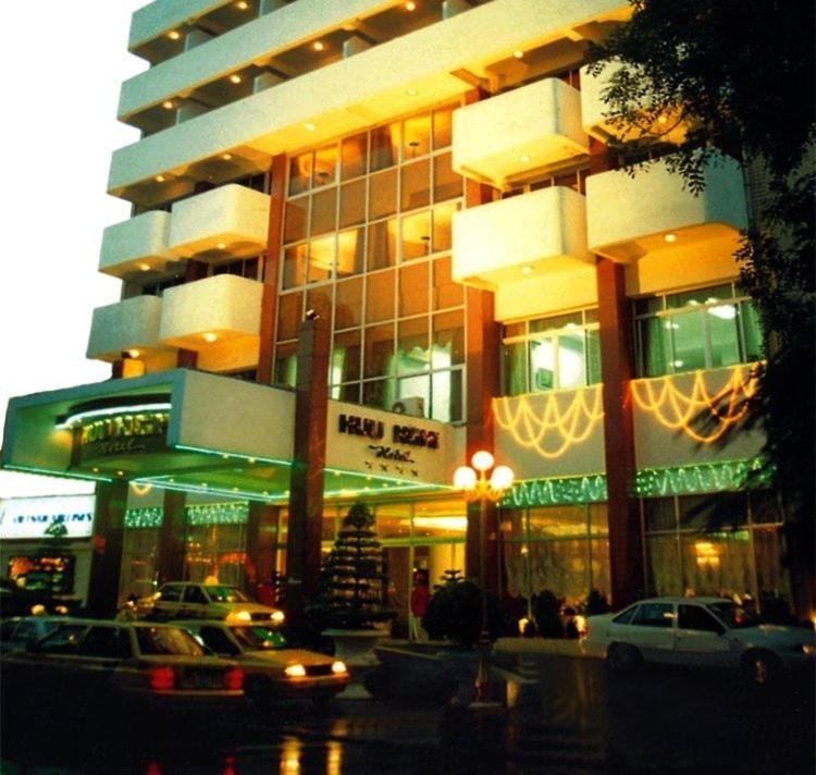 a large building with cars parked in front of it at Huu Nghi Hotel in Hai Phong