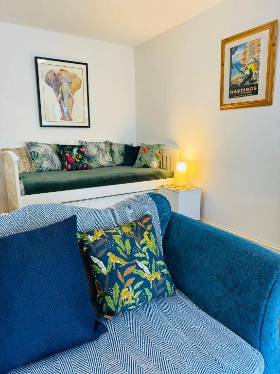 a blue couch in a living room with a bench at Cavernous open plan town house in st Leonards in St. Leonards