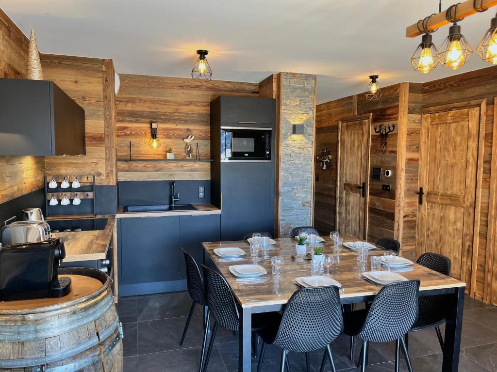 une salle à manger avec une table et une cuisine dans l'établissement Appartement de standing 8 au pied des pistes - OLVERA 202, à Valmeinier