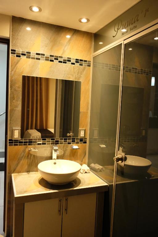a bathroom with a sink and a mirror at Hotel Puma'r Tacna in Tacna