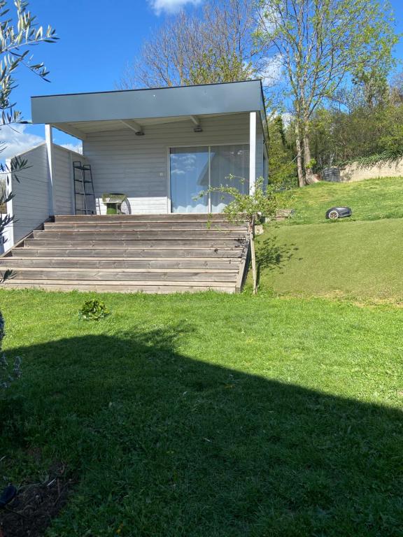 a small house with stairs and a grass yard at Bungalow dans le jardin in Saint-Étienne