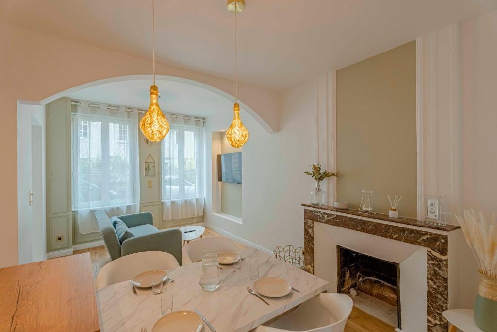 un salon avec une table et une cheminée dans l'établissement Petit Appartement Cosy proche Centre historique, à Caen
