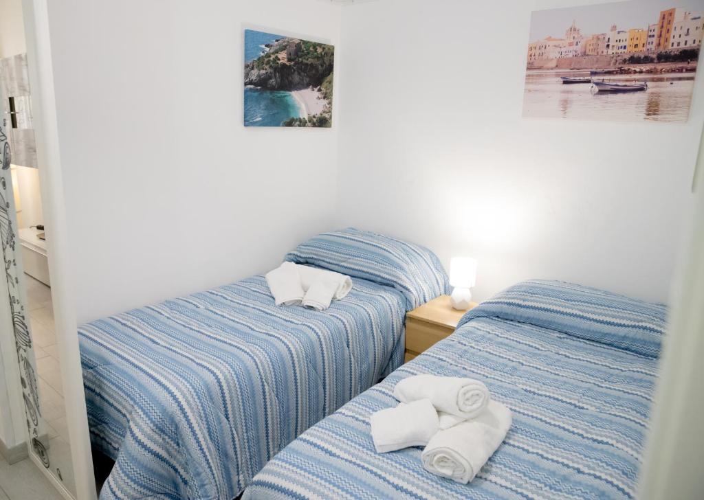 2 camas con toallas en un dormitorio en Casa Vacanze La Coccinella, en Trapani
