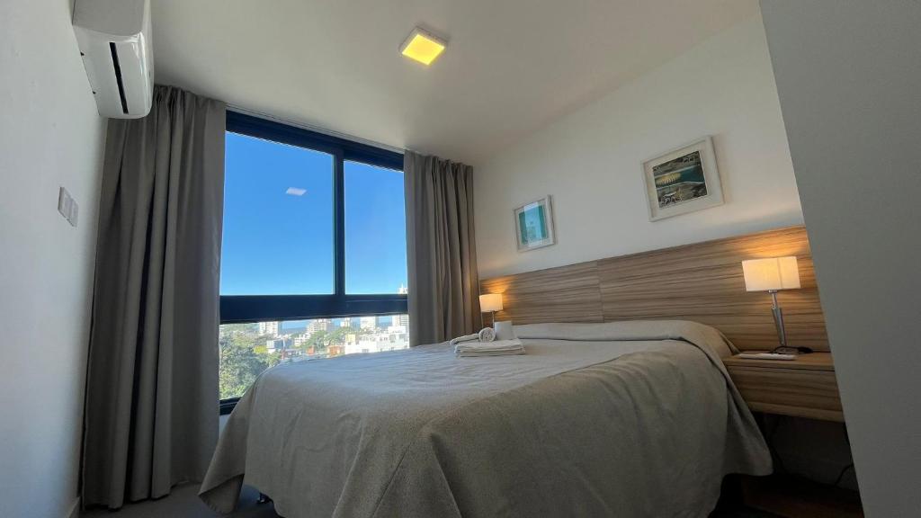 a bedroom with a bed and a large window at Michelangelo 806 in Punta del Este