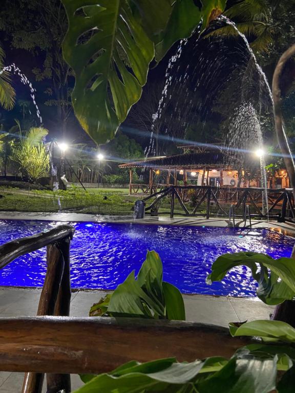 a fountain in front of a pool at night at EcoHotel Inka Minka in Santa Marta