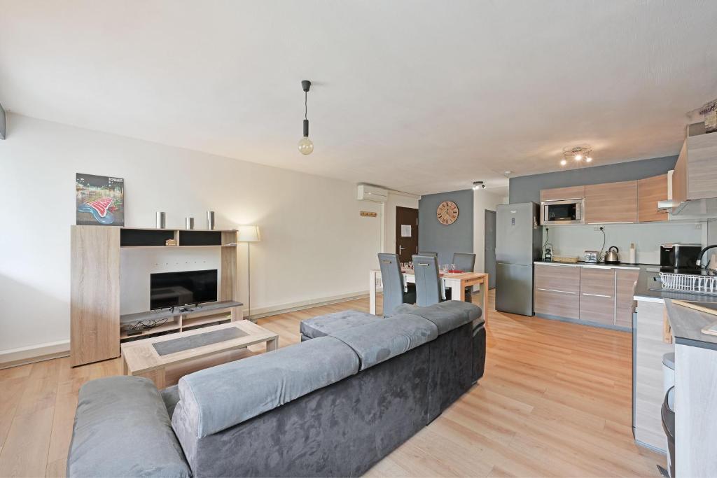 un salon avec un canapé et une cuisine dans l'établissement O'portes de la gare-parking-clim-5mins centre-ville, à Avignon