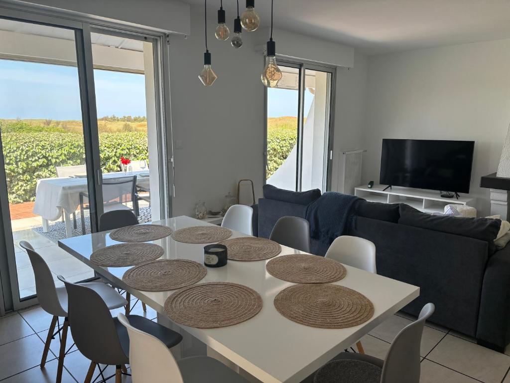 un salon avec une table, des chaises et un canapé dans l'établissement villa plage les Sables d’Olonne, à La Chaume