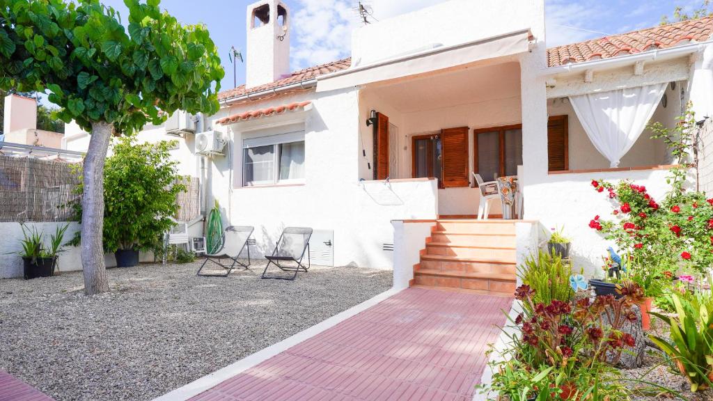 een wit huis met stoelen en een patio bij Casa Uly in Riumar