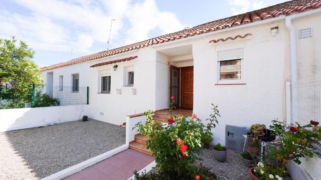 a white house with a courtyard in front of it at Casa Uly in Riumar