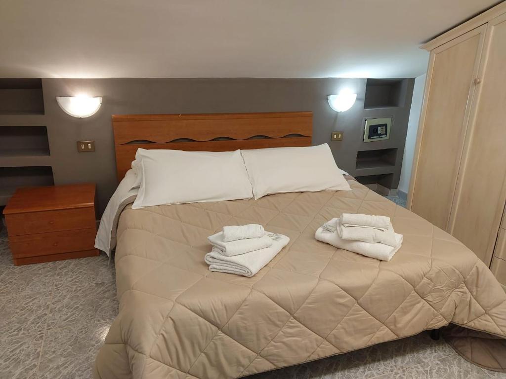 a bedroom with a bed with towels on it at rooms speedy vicino aeroporto e fiera di roma in Fiumicino
