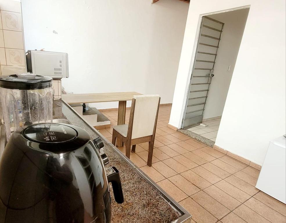 a kitchen with a tea kettle and a table at Quarto Proença in Campinas