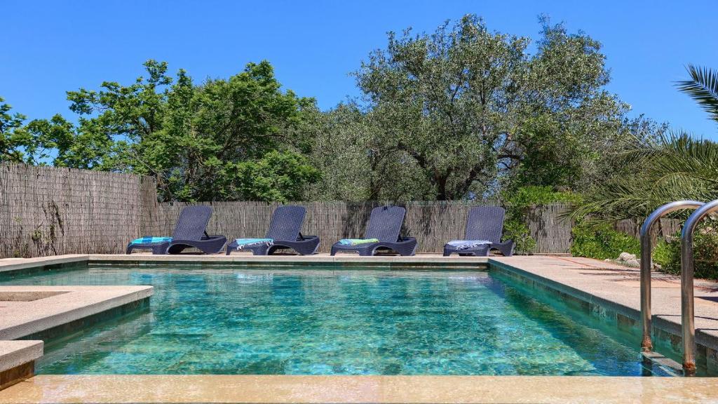 a swimming pool with lounge chairs next to a fence at Villa Josefina in Pollença