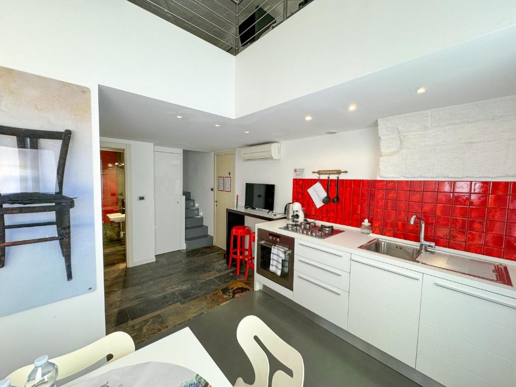 a kitchen with white cabinets and red tiles at Vingt Sept in Polignano a Mare