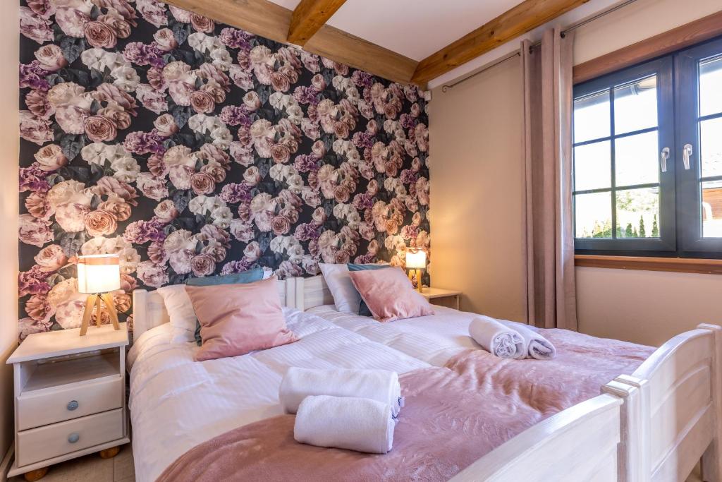 a bedroom with a bed with a floral wall at Jesteśmy Na Ty - Apartamenty in Lewin Kłodzki