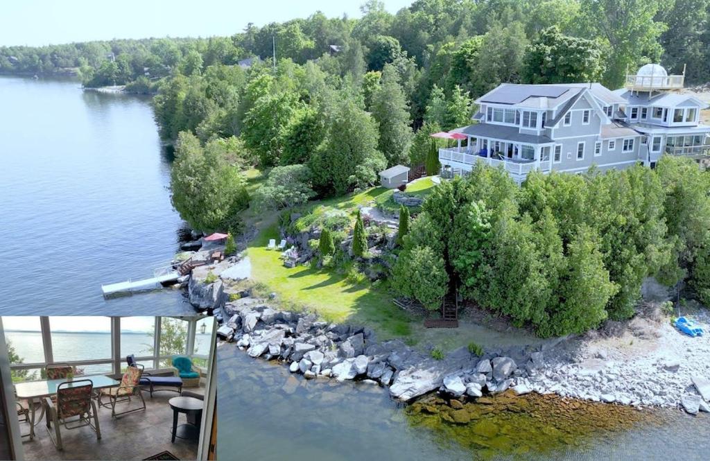 an aerial view of a large house on an island in the water at Loza house adirondack screened-in porch unit lake front in Plattsburgh
