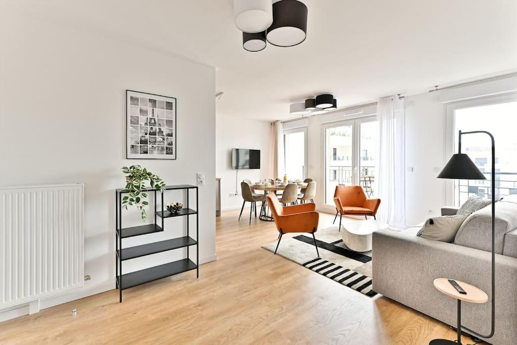 un salon avec un canapé et une salle à manger dans l'établissement Appartement 3 Chambres Mairie Saint-Ouen, à Saint-Ouen