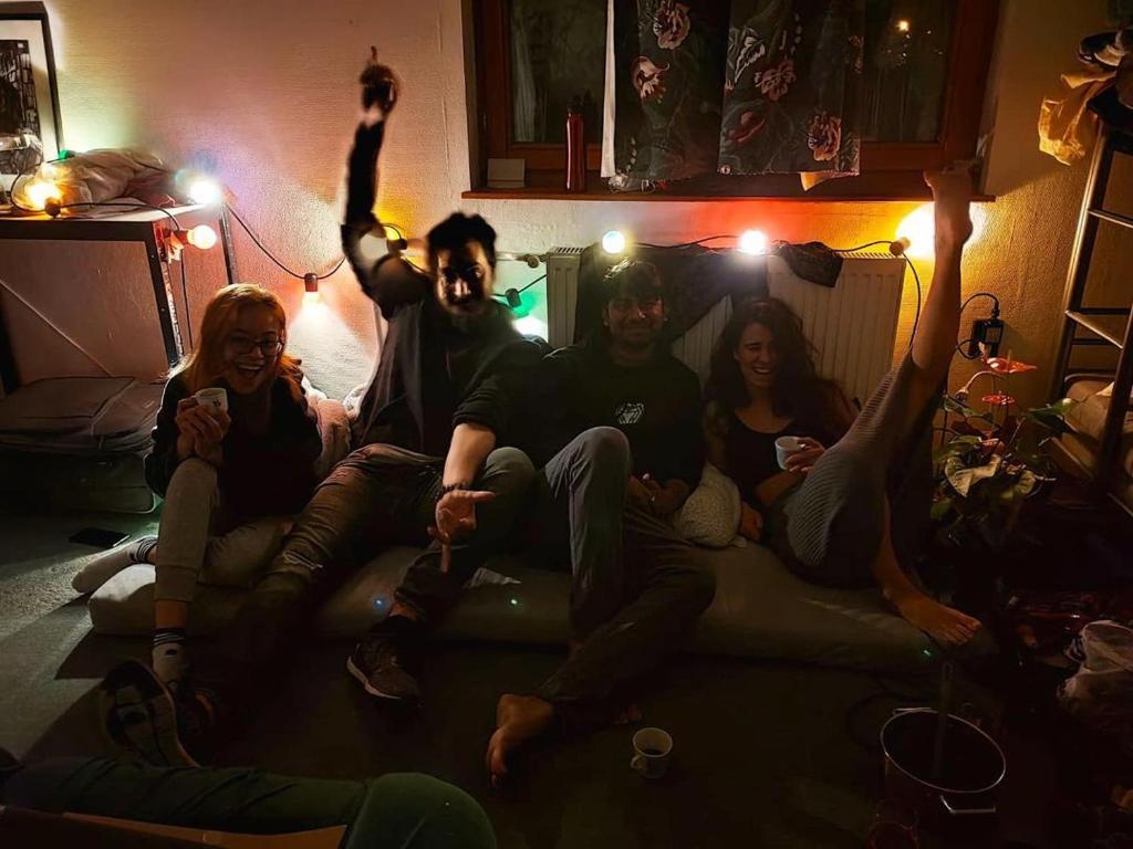 eine Gruppe von Menschen, die auf einer Couch in einem Zimmer sitzen in der Unterkunft Budapest Garden Hostel in Budapest