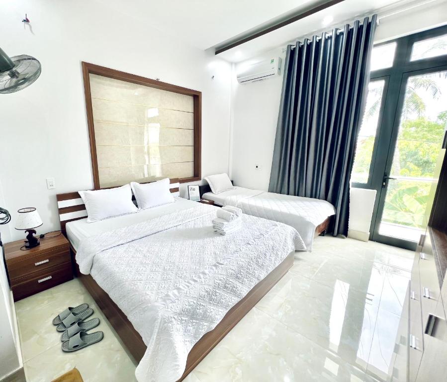 a bedroom with two beds and a window at 150 Homestay in Dong Hoi