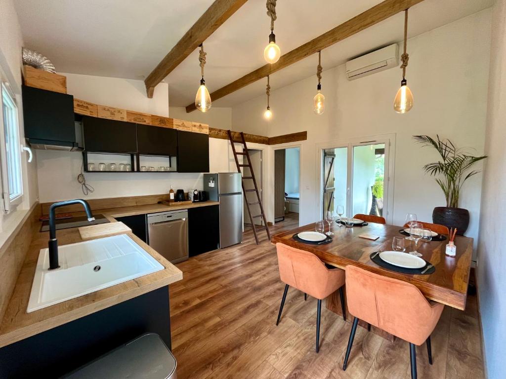 une cuisine et une salle à manger avec une table et des chaises en bois dans l'établissement Coup de cœur charmante maison aux bois murés, à Grasse