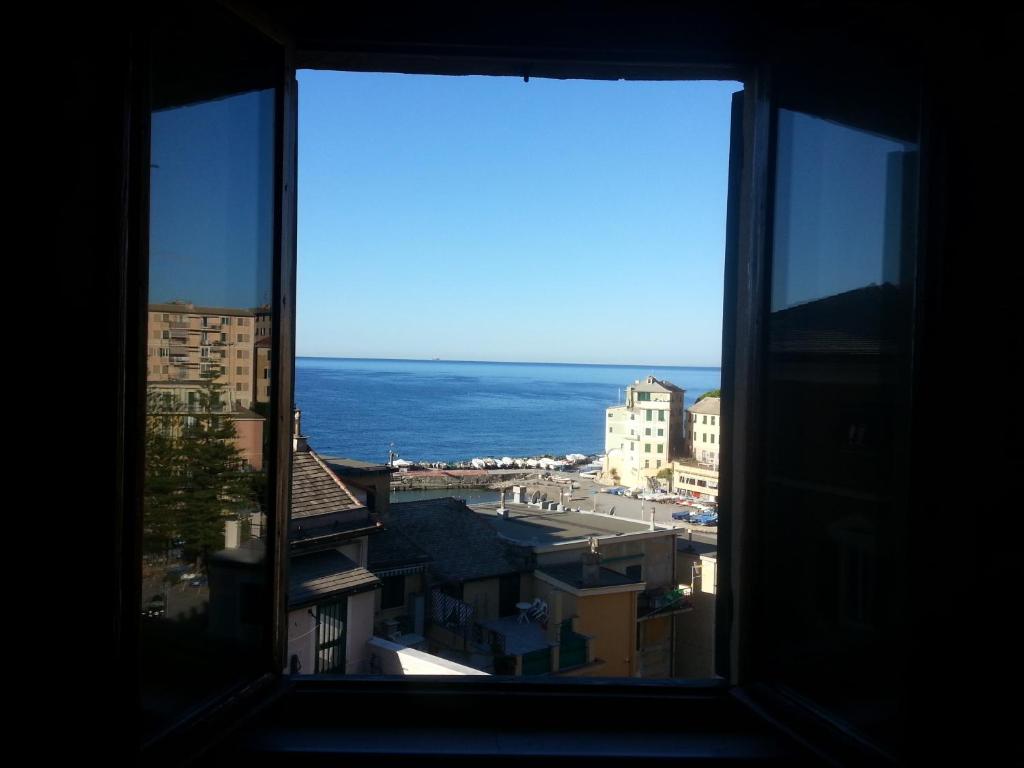 een raam met uitzicht op de oceaan vanuit een gebouw bij Sopra La Spiaggia in Bogliasco