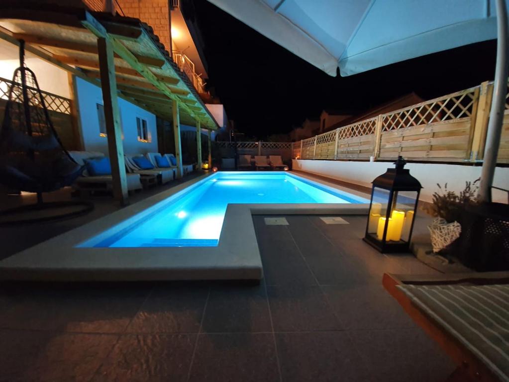 a swimming pool at night with a light on the side at B&B Buzolic in Hvar