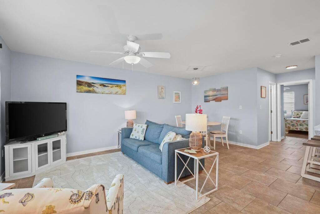 ein Wohnzimmer mit einem blauen Sofa und einem Fernseher in der Unterkunft Condo in Gulf Shores King Suite in Gulf Shores