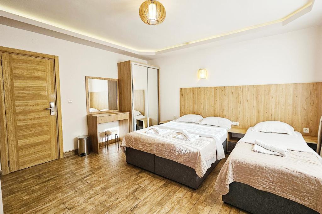 a hotel room with two beds and a mirror at Villa Montemaris Budva in Budva