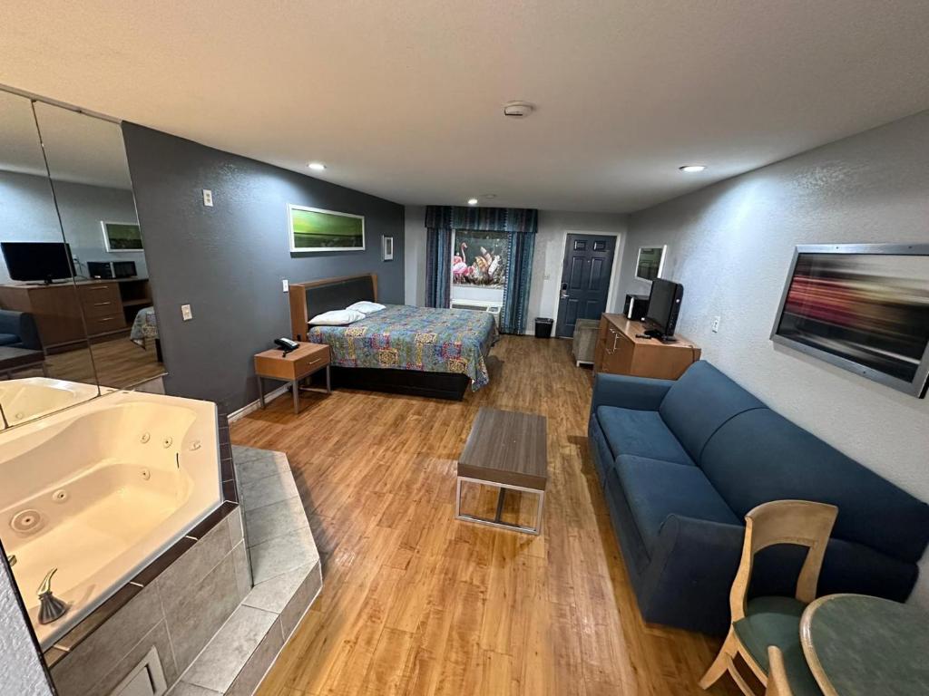 sala de estar con sofá azul y cama en Mustang Inn and Suites, en San Antonio