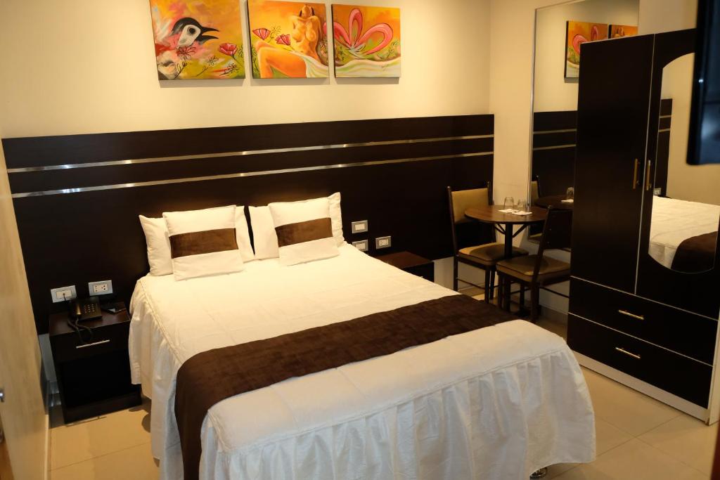 a hotel room with a bed and a television at Hotel Puma'r Tacna in Tacna