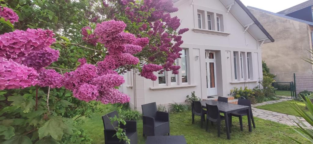 a house with purple flowers in the yard at Villa des roses, comme à la maison in Cherbourg en Cotentin