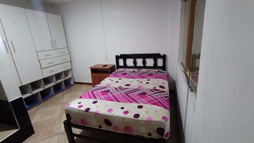 Urbanizacion Buenos Aires的住宿－House Yupanqui，一间小卧室,配有一张带波卡圆点的床
