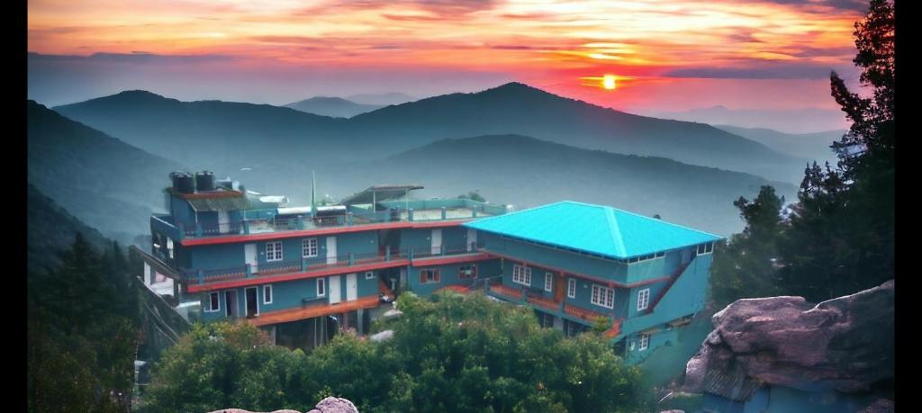 a building with a blue roof in the mountains at Mountain View Villas of Coorg in Madikeri