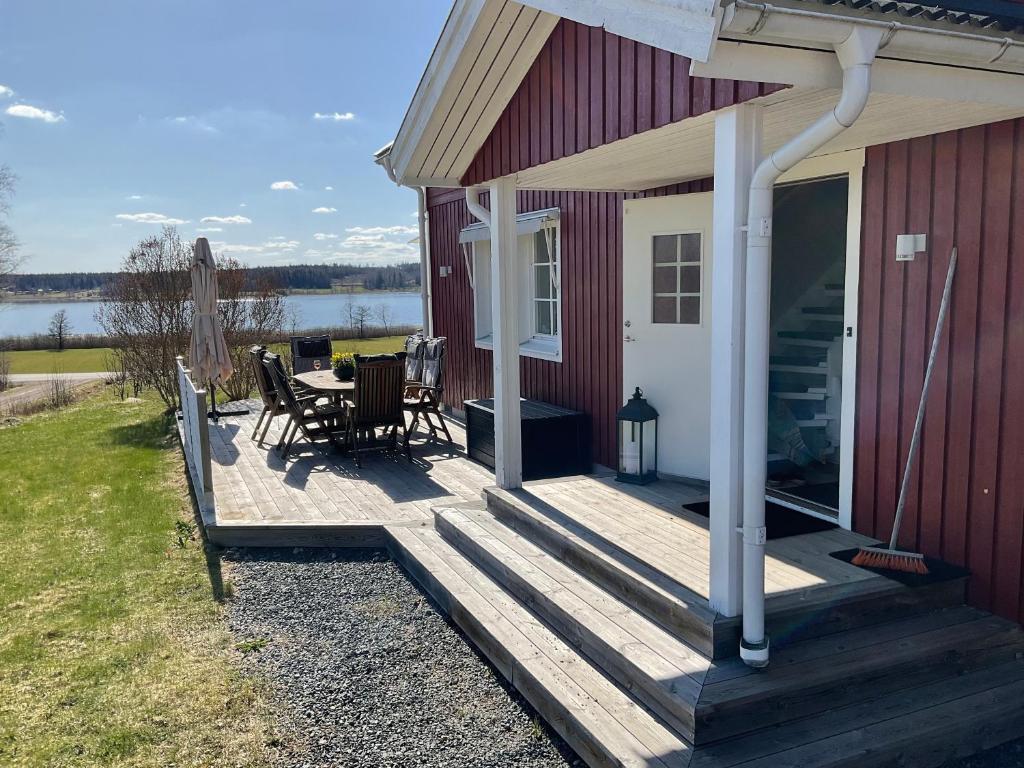 una veranda di una casa rossa con tavolo e sedie di Villa med sjöutsikt a Fors