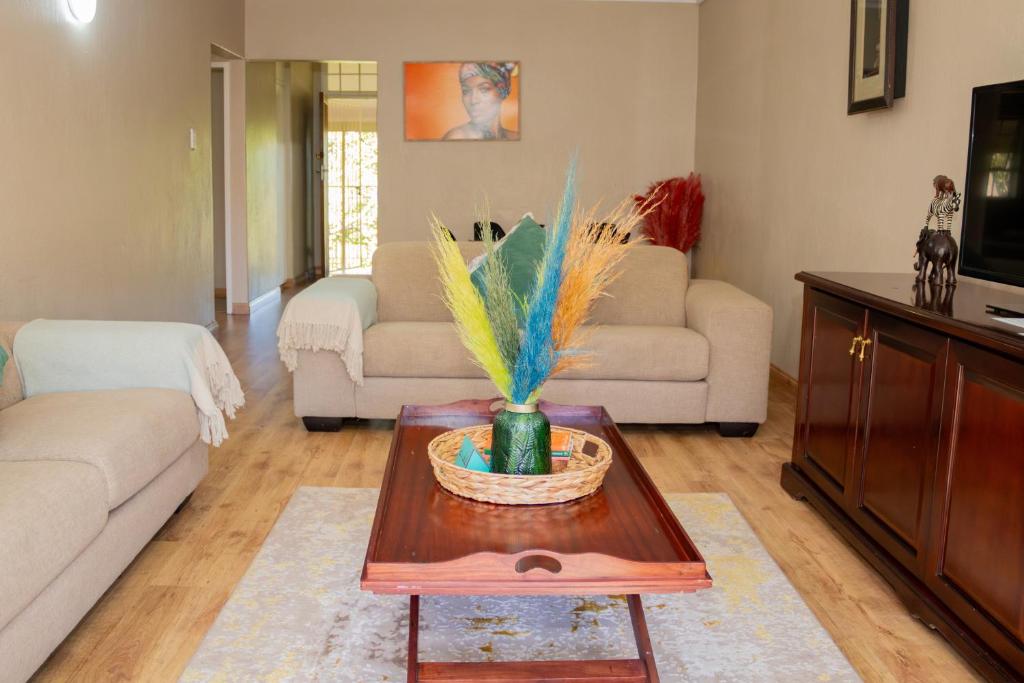 una sala de estar con una mesa con un jarrón. en Delightful spacious two bedroom apartment, en Johannesburgo