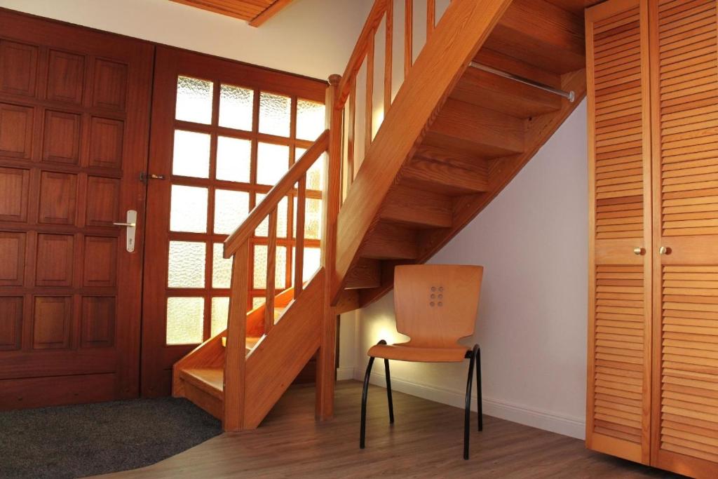 escalera de madera en una habitación con silla en Ferienhaus für 4 Personen ca 110 qm in Risum-Lindholm, Schleswig-Holstein Kreis Nordfriesland, en Risum-Lindholm