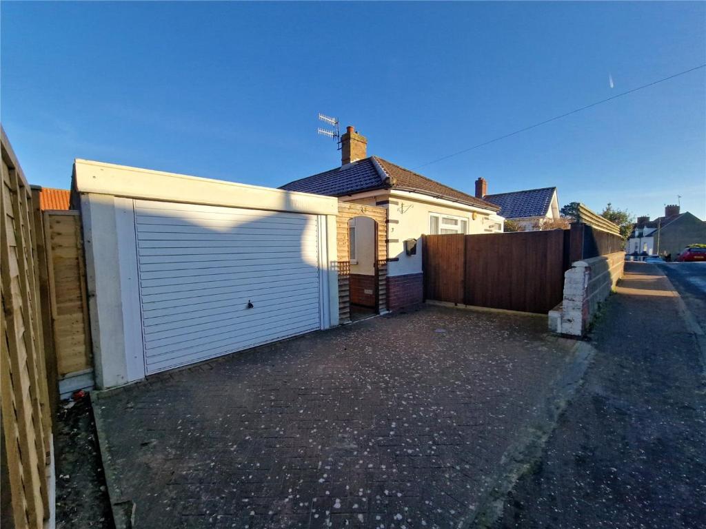 a house with a white garage door on a driveway at 3 Harbord road in Cromer