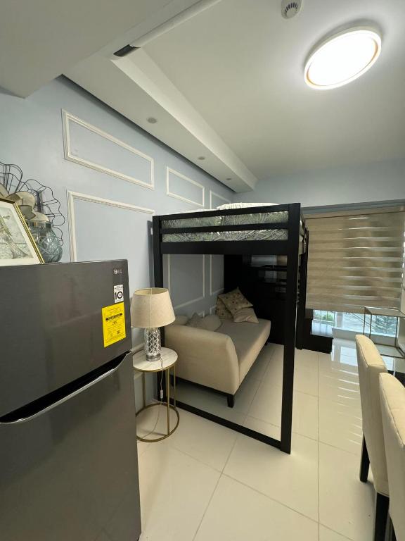 KaybagalにあるSmdc wind residencesのベッドルーム1室(二段ベッド1組、ランプ付きテーブル付)