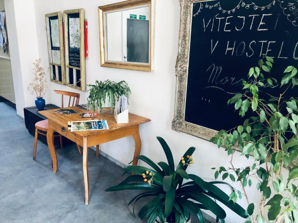 a desk and a chalkboard on a wall with plants at Hostel Moravia Ostrava in Ostrava