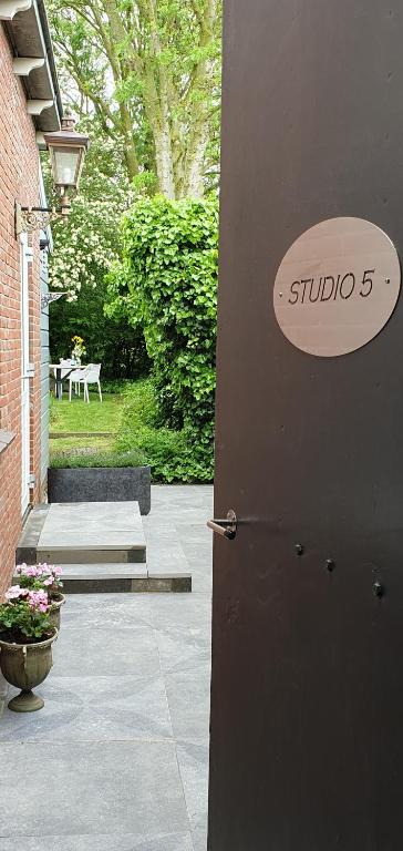 eine Tür zu einem Haus mit einem Schild darauf in der Unterkunft Studio 5 Walcheren in Grijpskerke