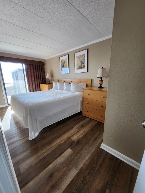 - une chambre avec un grand lit blanc et une fenêtre dans l'établissement St. Tropez, à Ocean City
