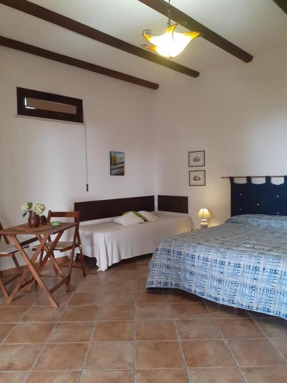 sypialnia z 2 łóżkami i stołem w obiekcie Panorama Casa Vacanze w mieście Marsala