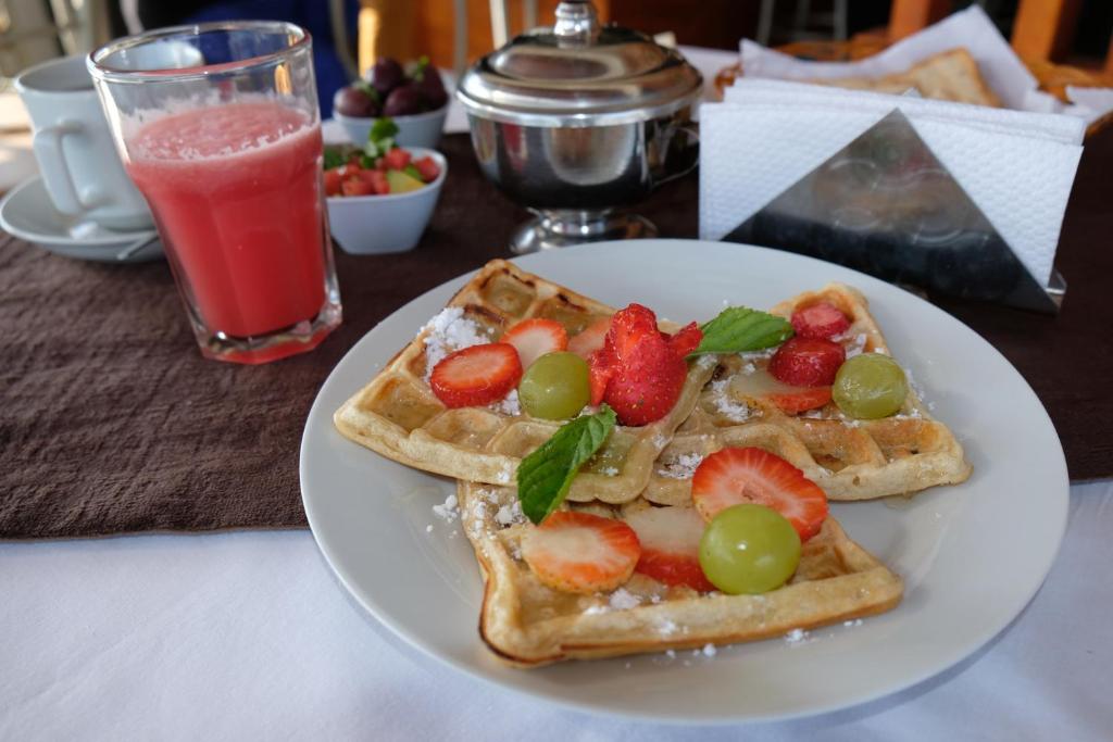 a white plate with two waffles with fruit on it at Hotel Puma'r Tacna in Tacna
