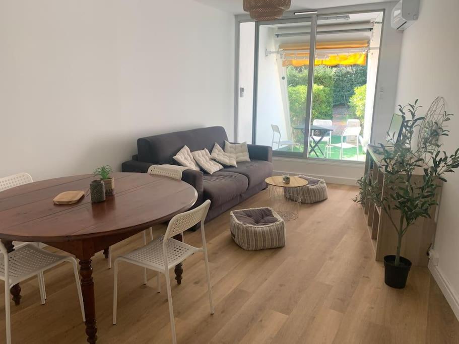 un salon avec une table et un canapé dans l'établissement Appartement cosy climatisé proche plage, à La Grande Motte