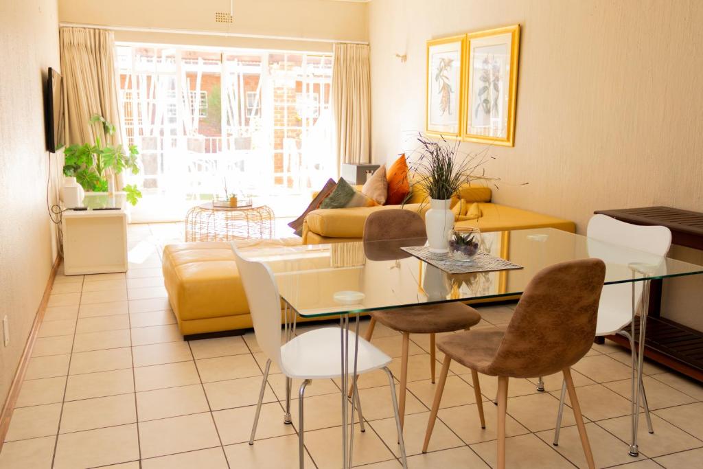 uma sala de estar com uma mesa e um sofá em Lovely Spacious Two bedroom apartment em Joanesburgo
